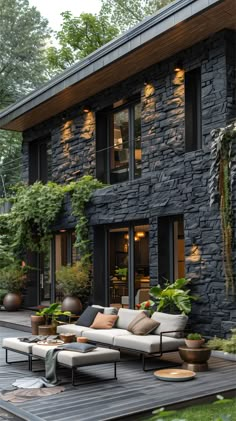 an outdoor living area with couches, tables and potted plants on the deck