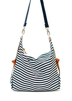 "The Marina diaper bag has been designed for your everyday life, able to carry anything you may need during your daily activities The bag is made from a cotton canvas, in a nice navy blue and white striped pattern and has leather details at the sides, which provides a very nice shape. It closes with a zipper and it is fully lined with a cotton canvas, with the color of your choice (yellow or light grey). This Marina diaper bag has one strap, made from a thick cotton twill in navy blue color, whi Everyday Striped Canvas Bag, Everyday Canvas Tote Bag With Striped Lining, Everyday Tote Canvas Bag With Striped Lining, Everyday Use Canvas Tote Bag With Striped Lining, White Canvas Diaper Bag, Striped Cotton Travel Bags, Navy Cotton Shoulder Bag For Everyday Use, Travel Bags With Striped Cotton Design, Canvas Bags With Striped Lining For Everyday Use