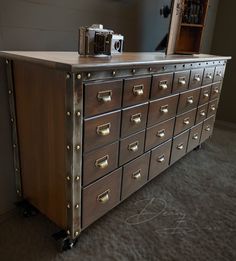 an old dresser with many drawers and a camera sitting on it's top shelf