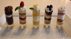 five desserts in small glass containers on a table