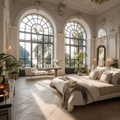 a large bedroom with high ceilings and arched windows