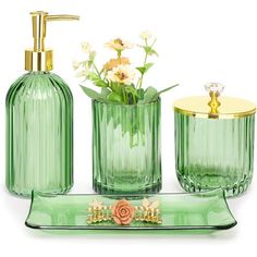 green glass bathroom accessories including soap dispenser, toothbrush holder and vase