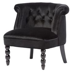 an upholstered black velvet chair with wooden legs and buttoned backrests