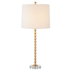 a table lamp with a white shade on it and a gold metal frame around the base