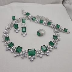 Doublet Necklace feature beautiful big green gemstone and cubic zirconia. Perfect for weddings, this statement piece is designed to dazzle. An ideal bride gift, it also makes a thoughtful present for your sister, adding elegance and charm to any special occasion. *𝐏𝐑𝐎𝐃𝐔𝐂𝐓 𝐃𝐄𝐓𝐀𝐈𝐋* * 𝐌𝐚𝐭𝐞𝐫𝐢𝐚𝐥: Brass * 𝐏𝐥𝐚𝐭𝐢𝐧𝐠: White Rhodium Plated * 𝐒𝐭𝐨𝐧𝐞: AAA-quality CZ Diamond & Doublet. 𝐕𝐢𝐬𝐢𝐭 𝐎𝐮𝐫 𝐅𝐀𝐐𝐬 𝐟𝐨𝐫 𝐒𝐡𝐢𝐩𝐩𝐢𝐧𝐠 𝐏𝐨𝐥𝐢𝐜𝐢𝐞𝐬 𝐚𝐧𝐝 𝐂𝐚𝐫𝐞 𝐈𝐧𝐬𝐭? Luxury Traditional American Diamond Necklace, Wedding Silver Emerald Necklace With Cubic Zirconia, Wedding Silver Emerald Cubic Zirconia Necklace, Luxury Wedding Jewelry Sets With Gemstones, Hand Set Crystal Emerald Necklace For Wedding, Formal Emerald Cut Cubic Zirconia Necklace, Emerald Cut Cubic Zirconia Wedding Jewelry, Wedding Emerald Crystal Necklace Hand Set, Fine Jewelry Emerald Necklace With 17 Jewels For Wedding