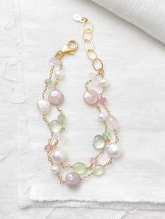 This luxe layered bracelet boasts a lavish combination of pink and green gemstones and freshwater pearls, creating a refined and feminine design. Lobster clasp and extender chain allow for an adjustable fit. Bracelet length:  7.5-8.5 inches Materials:  gold fill, rose quartz, prehnite, tourmaline, mystic moonstone, green amethyst, cultured freshwater pearls GIFTING ~ Jewelry gift box included. ~ I am happy to ship directly to the recipient.  Enter their address during checkout. ~ If you would like a gift note included in the package, please leave the text of the note in the "Add a note to Marsh Creek Jewelry" message box at checkout. FREE SHIPPING ~ Orders ship within 2 business days. ~ Free shipping is First Class ~ Priority Mail and Express Shipping upgrades are available during checkout Keshi Pearl Bracelet, Green Gemstone Bracelet, Boho Chic Bracelets, Layered Bracelet, Pearl Gifts, Gemstone Beads Jewelry, Chic Bracelet, Richmond Hill, Message Jewelry