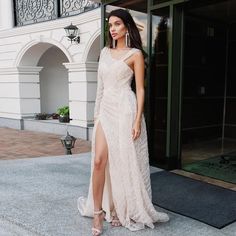 a woman in a white dress standing outside