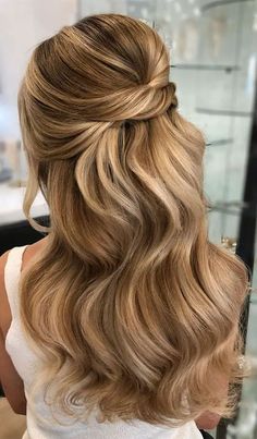 a blonde woman with wavy hair in a half updo