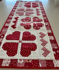 a red and white table runner with hearts on it