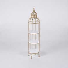 a gold metal birdcage with two shelves