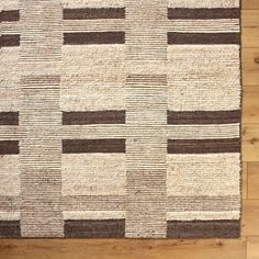 a brown and white rug on top of a wooden floor