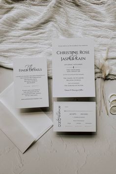 the wedding stationery is laid out on a bed