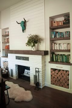 a living room filled with furniture and a fire place next to a bookshelf