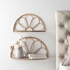 two wall shelves with flowers and books on them next to a white bed in a bedroom