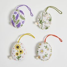 four handmade ornaments with flowers on them