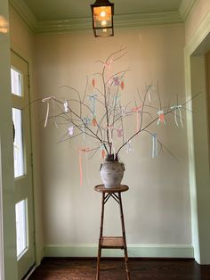 a vase filled with flowers sitting on top of a wooden table next to a doorway