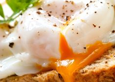 an open face sandwich topped with fried eggs and melted orange sauce on toasted bread