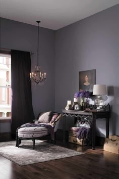 a living room filled with furniture and a chandelier hanging from the ceiling next to a window