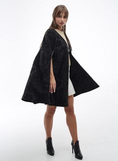 Wool Cape Women Loose Fit Cozy Stylish Oversized Coat  Poncho Cape - a women's mid-season coat crafted from a semi-woolen coat fabric in a loose, cape-like silhouette. The front panels feature slits for the arms, elegantly trimmed with faux leather. The garment is unlined. The cape is adorned with a patch and a leather closure with a loop and button. The fastening is along the edge with a loop closure and button. Back length: 81-84 cm. Fabric Composition: 80% Wool, 20% Polyester Oversized Cape Outerwear For Spring, Chic Spring Cape Outerwear, Oversized Chic Cape For Fall, Chic Oversized Cape For Fall, Oversized Long Sleeve Chic Cape, Oversized Chic Long Sleeve Cape, Chic Oversized Long Sleeve Cape, Oversized Winter Cape For Work, Oversized Wool Cape Coat For Fall