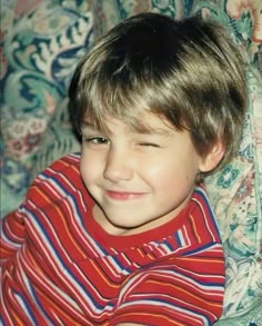 a young boy sitting on top of a couch