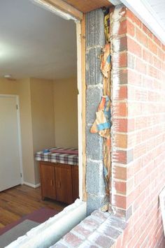 a brick wall in the corner of a room that has been torn off with tape