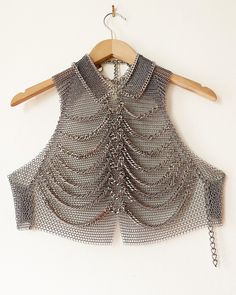 Falconiere ribcage vest. Halter vest with chainmail base and 8 rows of draped double link chunky chain. Small ring chainmail collar bordered in bordered by chain. Notched center front hem. Lobster claw clasps at high and low back neck with adjustable chains. Lobster claw clasps at center back and straps with adjustable chains. Stainless steel chainmail in two ring sizes. Silver-tone plated steel chain Made by me in the USA. 3 - 6 weeks, but please let me know if you need it sooner. If you need d Chainmail Crochet, Chainmail Vest, Professional Punk, Shoulder Jewellery, Chainmail Clothing, Shoulder Jewelry, Chainmail Jewelry, Chain Maille Jewelry, Collar Chain