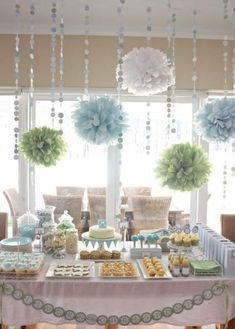 a table topped with lots of desserts and cupcakes next to a window