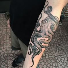 an octopus tattoo on the arm of a man