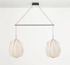 two white paper balls hanging from a metal bar