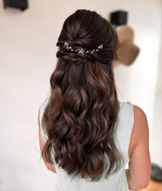 the back of a woman's head with long wavy hair in a half - up braid