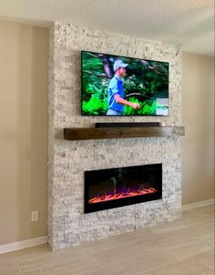 a flat screen tv mounted on the wall above a fireplace