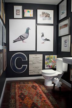 a bathroom with black walls and pictures on the wall