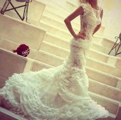 a woman in a white wedding dress standing on stairs with her hands on her hips