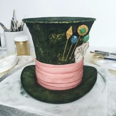 a green top hat sitting on top of a table next to scissors and other items