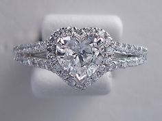 an engagement ring with a heart shaped diamond in the center