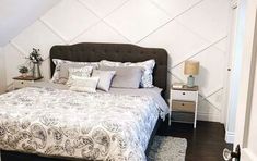 a bed room with a neatly made bed and pillows on it's headboard