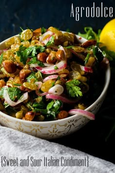 a white bowl filled with food next to a lemon and green leafy garnish