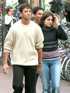 a man and woman walking down the street with bicycles in the backgrouds