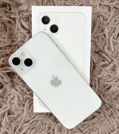 two iphones sitting next to each other on a carpet