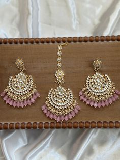 The perfect Chandbali Matching Tikka set for the upcoming season, these are made with the highest quality pachi kundan handwork that are real kundan stones. They come in 4 colors and come as a matching set of maang tikka and chandbali jhumka earrings. A statement piece to wear for weddings, sangeet, reception and mehendi etc events for the bride looking for a gorgeous timeless piece of jewelry to complete her look. It can also make as the perfect gift for any friend or bridesmaid for the festive Maang Tikka And Earrings Set, Luxury Kundan Jhumkas With Latkans, Luxury Kundan Tikka For Reception, Luxury Gold Hoop Earrings With Latkans, Luxury Tikka With Latkans For Festivals, Luxury Jhumkas With Latkans For Navratri, Hand Set Chandbali Tikka For Festivals, Anarkali Chandbalis With Gota Work And Kundan, Hand Set Chandbali Tikka For Diwali