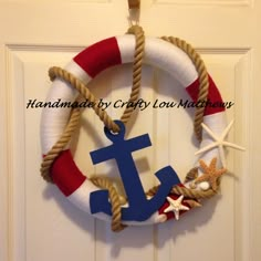 a wreath with an anchor, starfish and life preserver hanging on a door