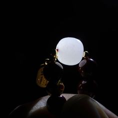 a close up of a person's hand holding an object in the dark,