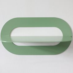 a close up of a green object on a white wall