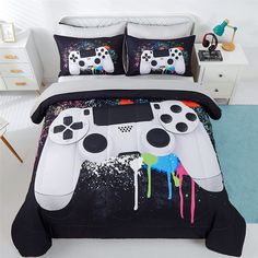 a bed with a video game controller comforter and pillows on top of it,