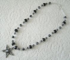 "This beautiful necklace has black pearl beads, black beads with silver engraved stars, seed beads, sterling silver plated filigree beads, pewter silver bead caps and a pewter silver pentagram. 18\" long. Sterling silver plated toggle clasp." Gothic Silver Beaded Necklace Perfect For Gifts, Gothic Silver Beaded Jewelry, Silver Gothic Beaded Necklace As Gift, Gothic Silver Necklaces With Round Beads, Gothic Silver Necklace With Round Beads, Silver Gothic Beaded Necklace For Gift, Silver Gothic Necklaces With Round Beads, Gothic Silver Beaded Necklaces With Black Beads, Goth Beaded Necklace