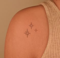 a woman's back shoulder with three stars on the left side of her arm