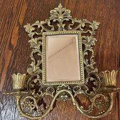 an ornate gold mirror on a wooden table