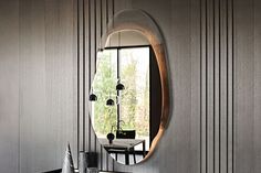 a bathroom sink sitting under a round mirror next to a wall mounted faucet