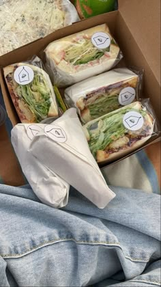 a box filled with sandwiches and wrapped in plastic