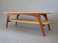 a wooden coffee table with two shelves on one side and a shelf on the other